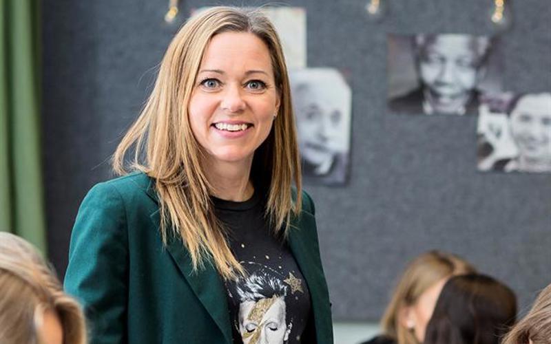Kvinna bland elever i klassrum