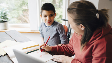 Lärare och elev vid ett bord.