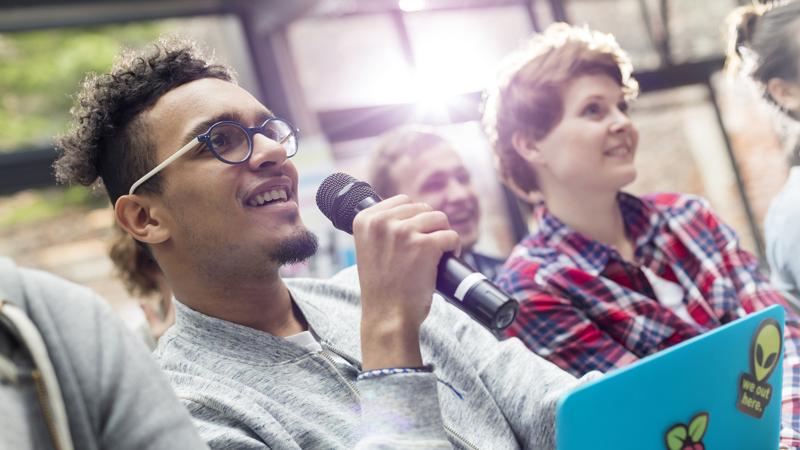 Ung man talar i mikrofon