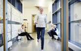 Leende flicka springer i skolans korridor