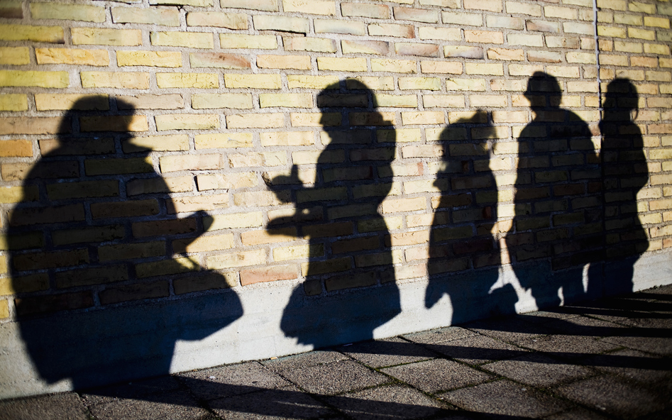 Skuggor av fem personer mot en vägg