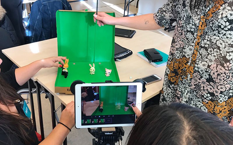 En grupp pedagoger filmar figurer framför en green screen.