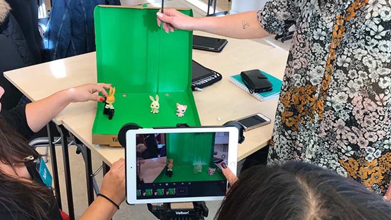En grupp pedagoger filmar figurer framför en green screen.