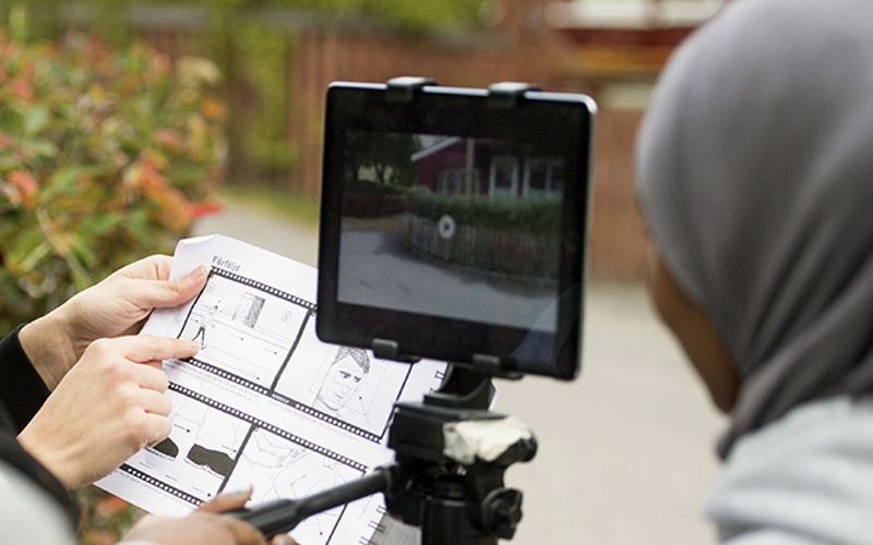 Filmning med Ipad på ett stativ och delar av ett bildmanus, foto