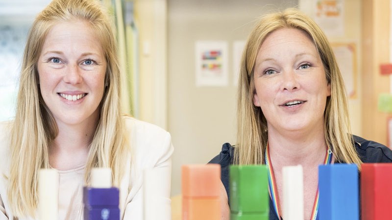 Två kvinnliga lärare i 40-årsåldern med klossar i olika färger framför sig i klassrummet.