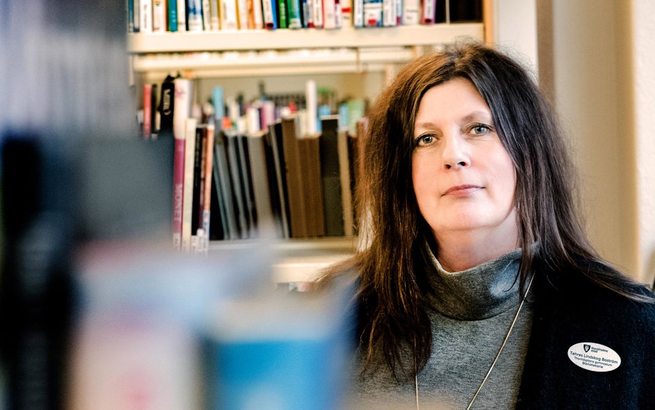 Kvinna med långt hår med böcker bakom ryggen