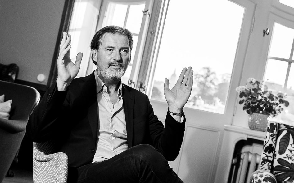 Jonas Aspelin sitter i en fåtölj och gestikulerar med händerna.