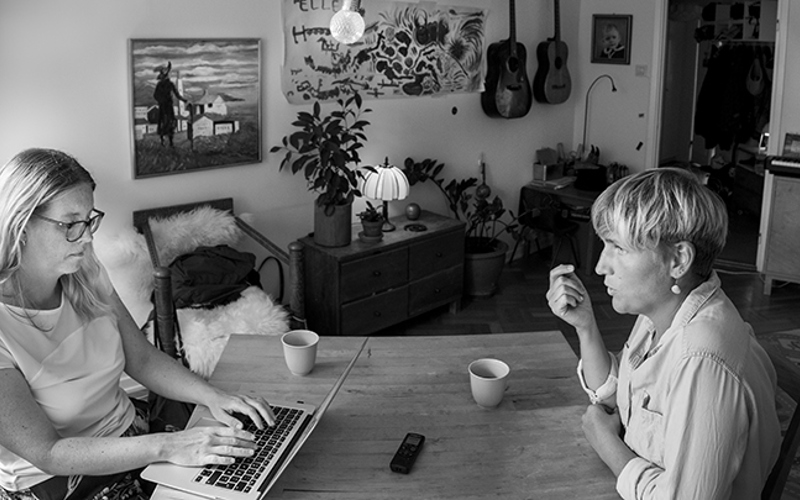 Forskaren Lina Lundström förklarar medan skribenten Annelie Drewsen skriver ner på sin dator.