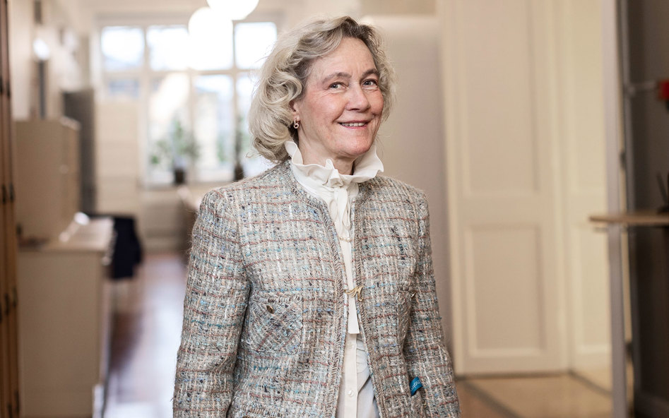 En leende Margaretha Orvarsson Hannfors står i en korridor.