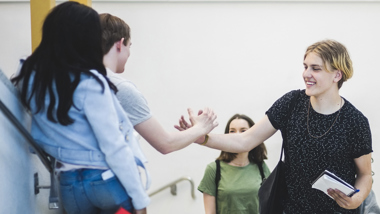 Elever som är på väg att ta varandra i hand.