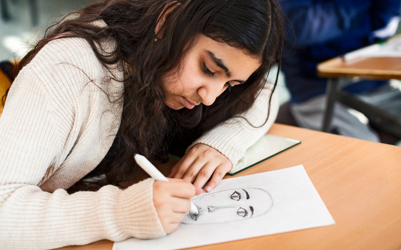 Elev som tecknar självporträtt.