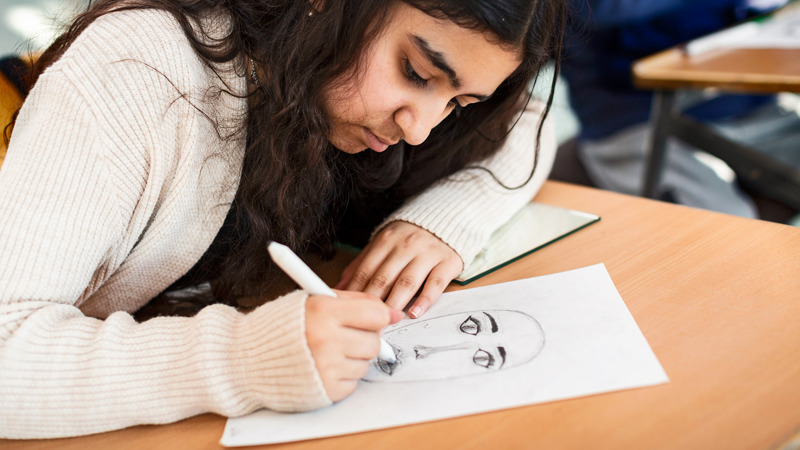 Elev som tecknar självporträtt.