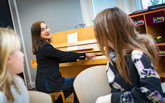 Lärare spelar piano för elever i klassrummet.