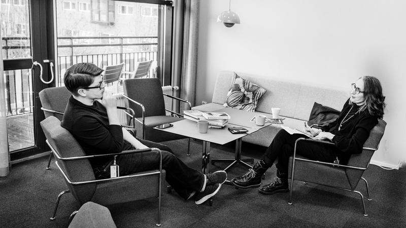 Två personer sitter i varsin fåtölj och samtalar.