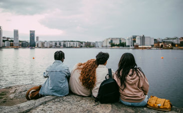 Fyra personer sitter på ett berg med utsikt över Stockholm.