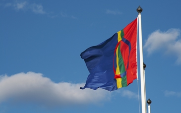 flagga på flaggstång med blå himmel bakom