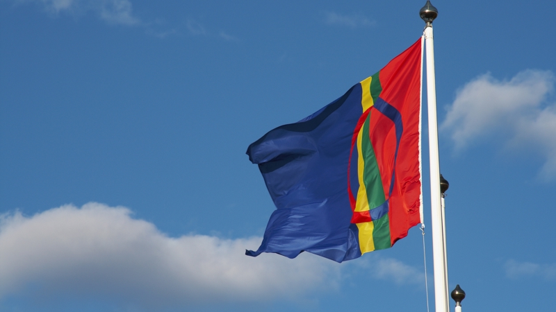 flagga på flaggstång med blå himmel bakom