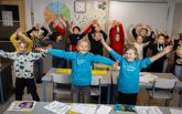 Lågstadieelever som gör rörelser i klassrum.
