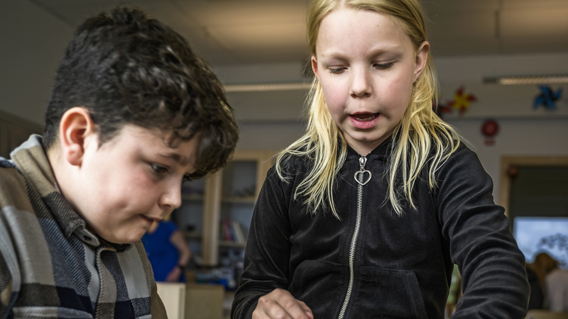 Två elever som jobbar vid ett bord.