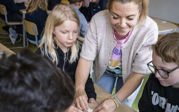 Läraren Anna Jeppsson visar sina elever hur man kan göra med ett batteri.