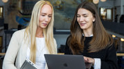 Två kvinnor tittar på en datorskärm. 