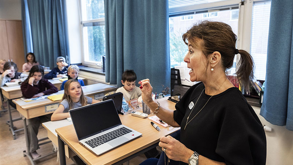 Lärare i klassrum talar inför grundskoleelever.