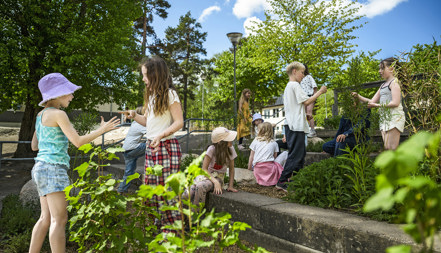 Skolelever leker på en grönskande skolgård.