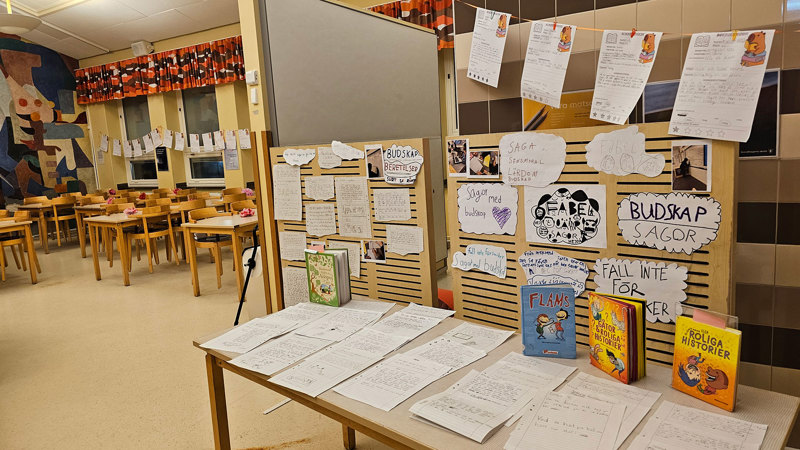 Matsal i skola dekorerad med böcker och teckningar.