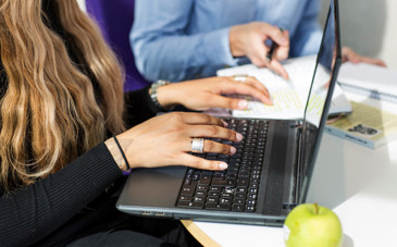 Kvinnohänder som skriver på en laptop