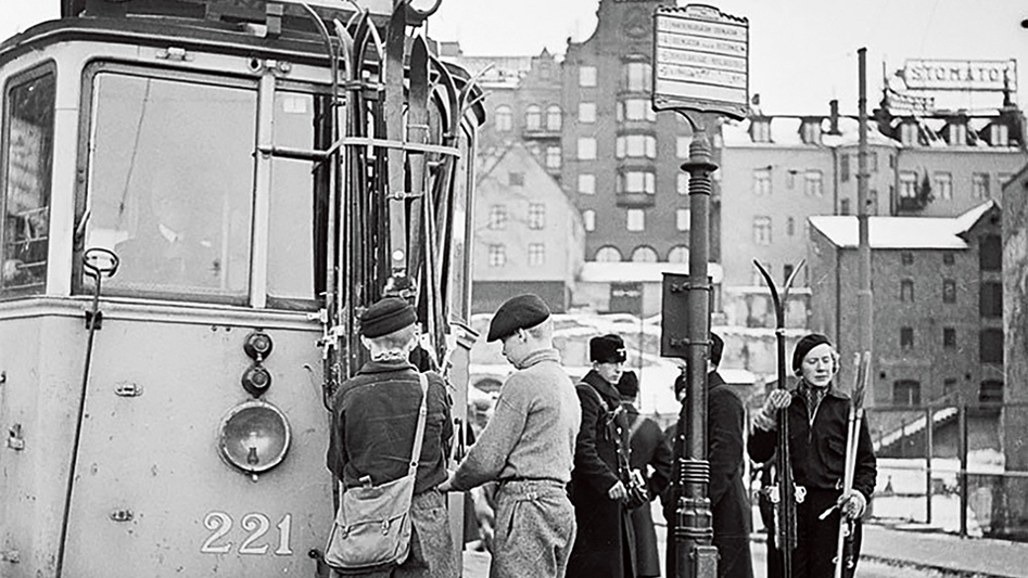 Elever står vid en spårvagn vid Slussen. Svartvitt foto från 1930-talet